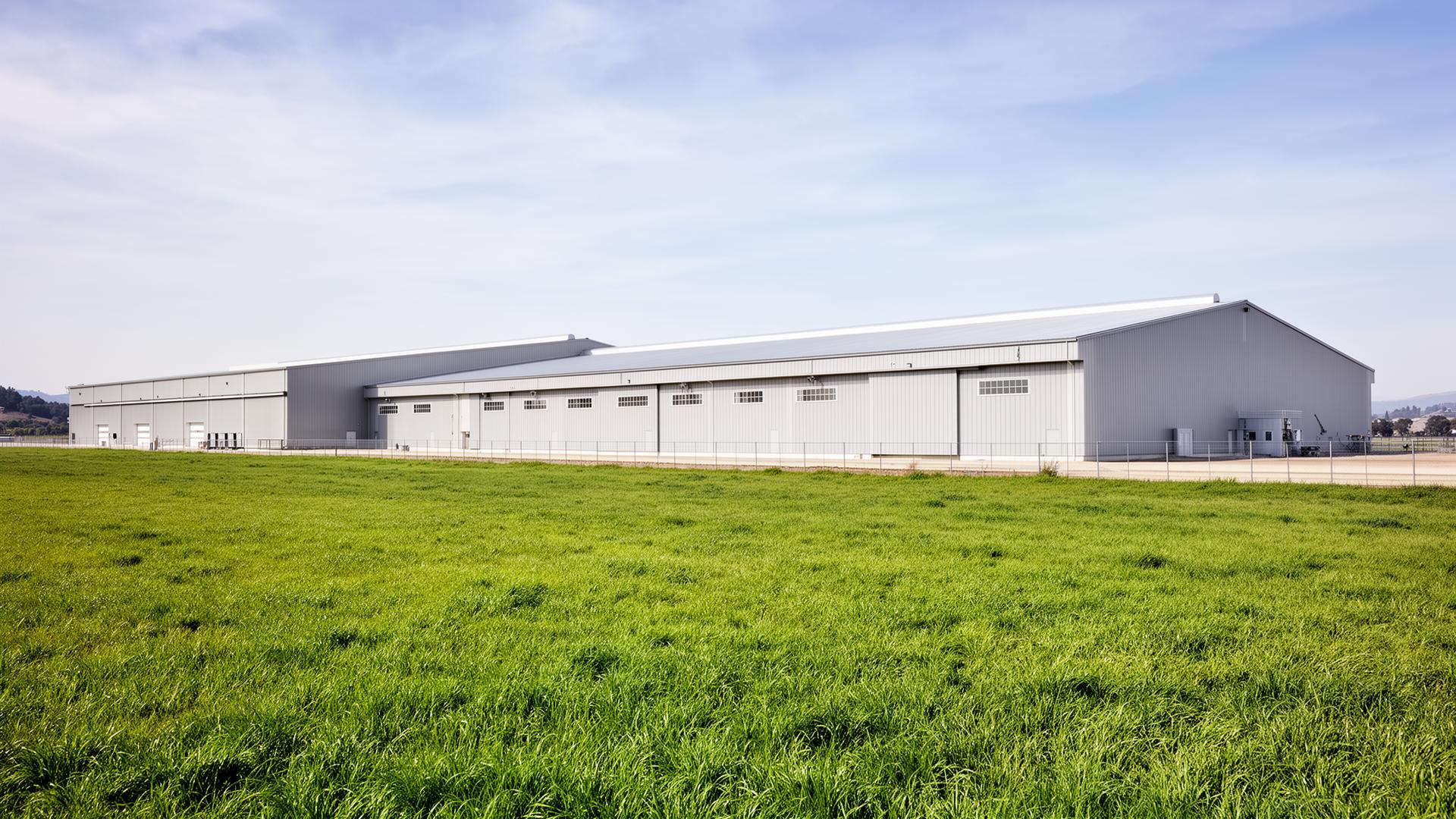 Exterior of long, modern commercial poultry barns in a rural California setting
